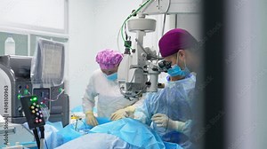 Ophthalmology operation in modern clinic. Medical team performing eye surgery using advanced equipment.
