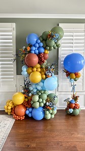 🍁 The coziest fall balloon garland you didn’t know you needed. I’m obsessed with how Periwinkle balloons mix with rich fall balloon colors to create this dreamy look. This design blends a freestanding balloon garland with a junior balloon column, making it perfect for any event. I love classic seasonal balloon palettes, but it’s always fun to push outside the box with unique balloon color combinations. The faux fall florals tucked into the balloon installation added the perfect autumn touch. Tr