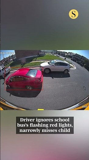 Driver ignores school bus's flashing red lights, narrowly misses child