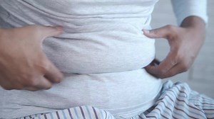 Overweight man shows the belly fat