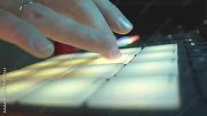 Man finger taps button conducting laser display at discotheque closeup. Lighting equipment engineer switches lamps on digital console in nightclub