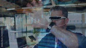 Animation of caucasian businessman analyzing graph data through virtual reality simulator in office