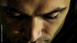Close-up on man's face with dramatic lighting and red evil vampire eyes