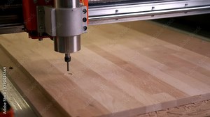 Drill the circle in motion on the board installed in the cnc wood router machine. Wood carving, automated woodworking