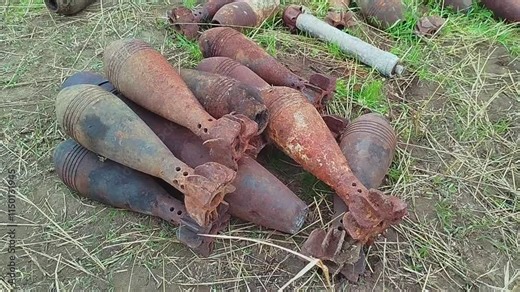 Burnt mortar shells lie on the ground. Mortar shells shattered by the explosion lie on the ground. High quality