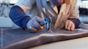 The leather craftsman produces leather products. Leather craftsman working with mallet and product at workshop. close up, slow motion. 4K