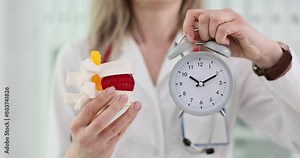 3D model of the spine with a hernia alarm clock in the hands of a doctor