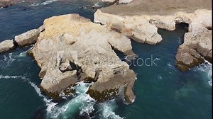 Aerial Point Arena rocky ocean cliff tourists hiking. Pacific Ocean coastal shoreline highway. California State Route 1, Mendocino County. Blue water, sand, rocky islands and cliffs. Seascape.