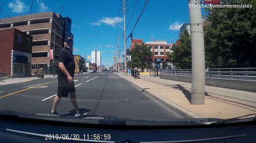 Jaywalking man stares down car and then walks into pole