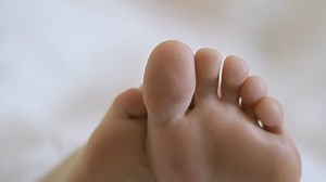 clip-1013146076-movement-toes-attractive-girl-bed