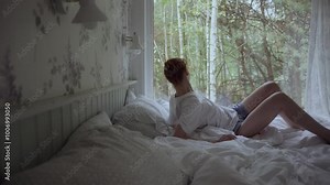 Sleepy, woman lying on bed and sleeping at home with forest view