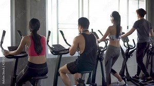 cycling machine and elliptical machine in gym club . fitness woman walking . workout . man sport working out on bike . rear back view . training .