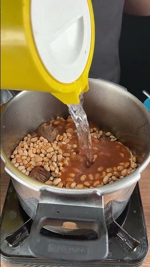 Complete beans in the pressure cooker with meats and seasonings