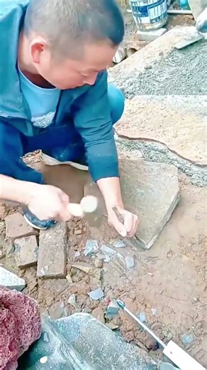 Chiseling stone surface manually using hammer and chisel