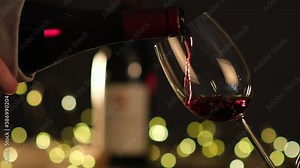 waiter pouring red wine in a glass on a wooden restaurant table