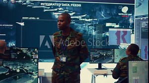 Platoon captain handling surveillance and safety operations with crew, dashboard to oversee field missions within enemy territory. Soldiers monitor CCTV satellite footage on big screen. Camera B.