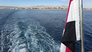 Safaga, Hurghada, Egypt - December 2021: View of the city and the red sea. Egypt flag on a yacht.