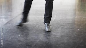 Single male tap dancer wearing black trousers and leather shoes dancing simple irish dance.