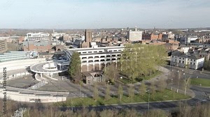 Covid virus suburban town lock down aerial view over quarantined British retail buildings and multi storey car park descending