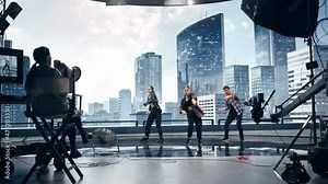 Music Clip Studio Set: Shooting Hip Hop Video Dance Scene with Three Professionals Dancers Performing on Stage with Big Led Screen with Modern City Background. Director and Cameraman in Backstage.