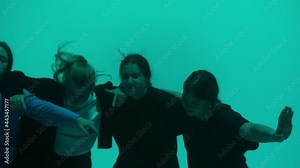 Group of professional choreographers dancing hip hop on color changing neon background in studio for dance video clip. Women dancers showing energetic movements. Advertising of dance school.