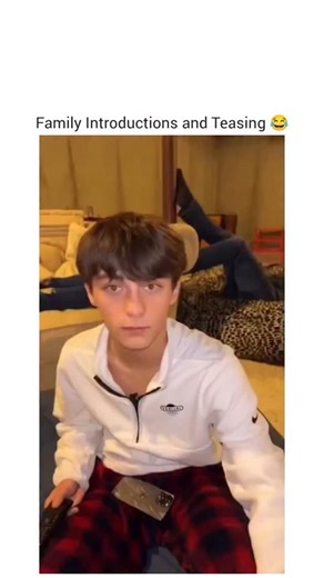 @gearheadgiggle on Instagram: "The video presents a series of candid, humorous introductions from various family members, each warning a hypothetical newcomer about a specific trait or habit of another family member. The setting shifts between different rooms in what appears to be a cozy family home, with each participant addressing the camera directly. The first to speak is Kevin, a boy in a white sweatshirt and red plaid pants, who sits on a bed holding a remote control. He warns the newcomer 