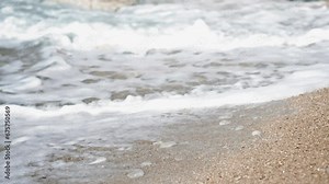 Cinematic slow-motion close-up of the sea surface and waves on the shore