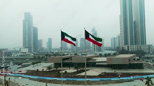 Kuwait flag waving in the sky with Kuwait buildings in the background