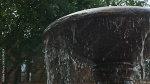 Beautiful view of an ancient city architecture. The park fountain throwing up water. View of Fountain splashing water. Water falling off a fountain plate crashing into thousands waterdrops.