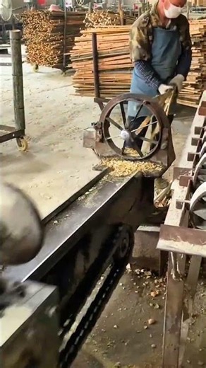 Splitting a long bamboo pole into multiple thin strips using an automatic machine in a factory