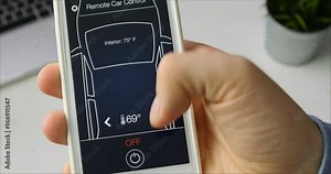 Man remotely changes temperature in his car Car remote control using smartphone application fictional interface.