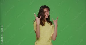 Smiling girl rocker show cool rock-n-roll gesture symbol by hands, make rock sign on chromakey green studio background