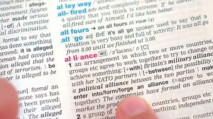 GDANSK, POLAND - NOVEMBER 2018: searching for and finding a word alliance definition in a dictionary