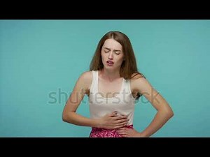 Painful cramp in stomach. Sick unhealthy girl clasping belly and suffering from severe abdominal