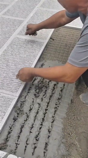 Using a three-pronged trowel to create patterns and the architecture of the tile installation
