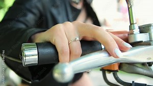 Hand on the throttle of a motorcycle. Bride in leather jacket sitting on a motorcycle.
