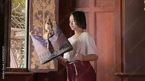 Young Asian girl practice Traditional Thai Puppet at wooden church in Thai temple, Pubic place for everyone in community around temple can use for activity.