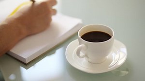 「女性はオフィスでメモ帳を使って仕事をし、時々新鮮なイタリアン・コーヒーを飲む」の動画素材（ロイヤリティフリー）7441204 | Shutterstock