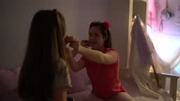 Sisters in the bedroom together playing clapping game at home - girl...