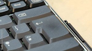 Man pressing an enter key on a laptop computer keyboard, finger pushing the key object detail closeup, one person. Accepting, confirming an action, sending a chat message simple abstract concept