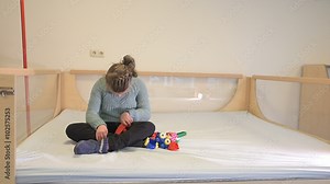 Disability a disabled child playing with her toys / Disability a disabled child playing with her toys with help from a special needs carer