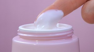clip-1050607939-woman-takes-white-hand-cream-pink-jar