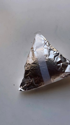 Kyrie | キリエ on Instagram: "Onigiri 🍙 Wrap Instructions: 1. Take a large sheet of nori and fold it in half, cutting into halves. 2. Rip a sheet of aluminum foil 3x the size of half the nori sheet. 3. Place the nori in the middle of the aluminum foil sheet (as shown in video), folding the sides of the foil inward to the middle of the nori, covering it completely. 4. Flip over and place a strip of tape in the middle about 1 inch longer than the aluminum foil (this will be used to pull the tape whe