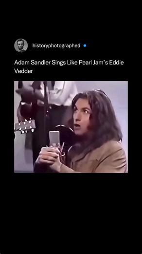 This is Adam Sandler impersonating Pearl Jam's Eddie Vedder during a classic 1993 Saturday Night Live skit, where he sang a parody of "Even Flow." The clip showcases Sandler's spot-on impression of Vedder's unique vocal style and stage delivery. Credit: @nbcuniversal /SNL | History In Pictures