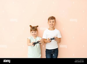Little children playing video games on color background Stock Photo - Alamy