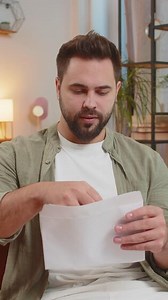 Happy man with brown hair open envelope letter, reading it. Career growth advance promotion, bank loan approve, successful admission to university monetary award invitation great news, lottery win.