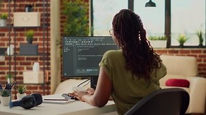 Young woman using source code to develop new online app, working with html script on terminal window to program database software. IT manager planning artificial intelligence network.