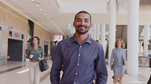 clip-1081987010-proud-business-man-walking-office-hallway-framing