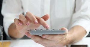 Woman sitting at table in office and counting on calculator 4k movie