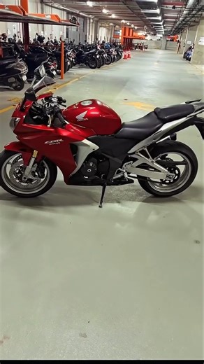 PROMPT - The key falls in smooth slow motion and transforms into a rotating motorcycle front tyre as it touches the ground, with soft dust flowing outward. Motorcycle parts enter from outside the frame in a strict step-by-step order: first the fuel tank, then the rear tyre, followed by all remaining components-frame, suspension, engine, exhaust, handlebars, seat, panels, cables, bolts, and body elements-each rotating, aligning, and attaching one by one with precise mechanical motion. The assembl